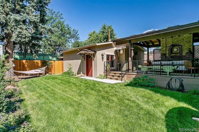 view of front of house with stucco siding, fence, and a front yard