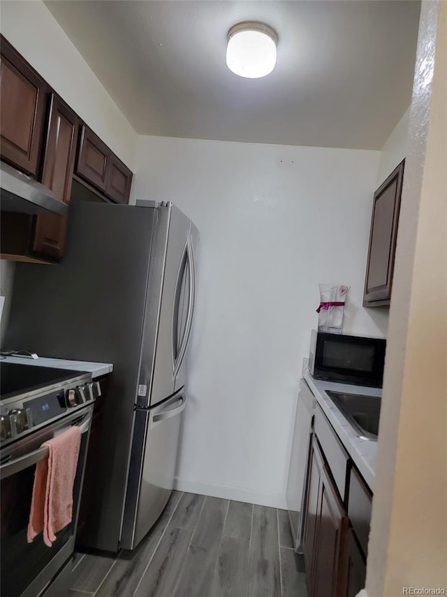 384 S Ironton St Unit 407, Aurora, CO 80012 - kitchen featuring stainless steel appliances, dark wood-style floors, light countertops, dark brown cabinets, and a sink