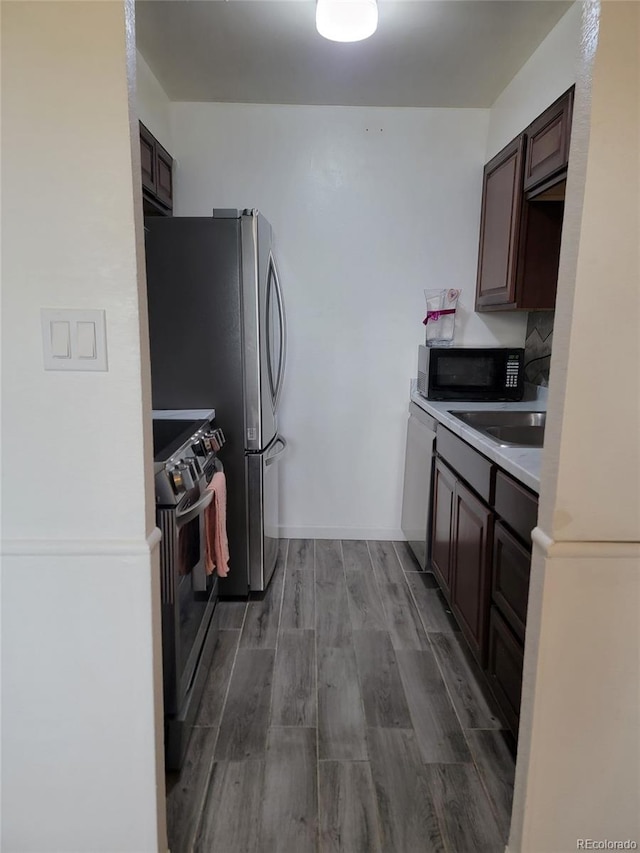 384 S Ironton St Unit 407, Aurora, CO 80012 - kitchen featuring stainless steel range oven, black microwave, wood finished floors, light countertops, and dark brown cabinets