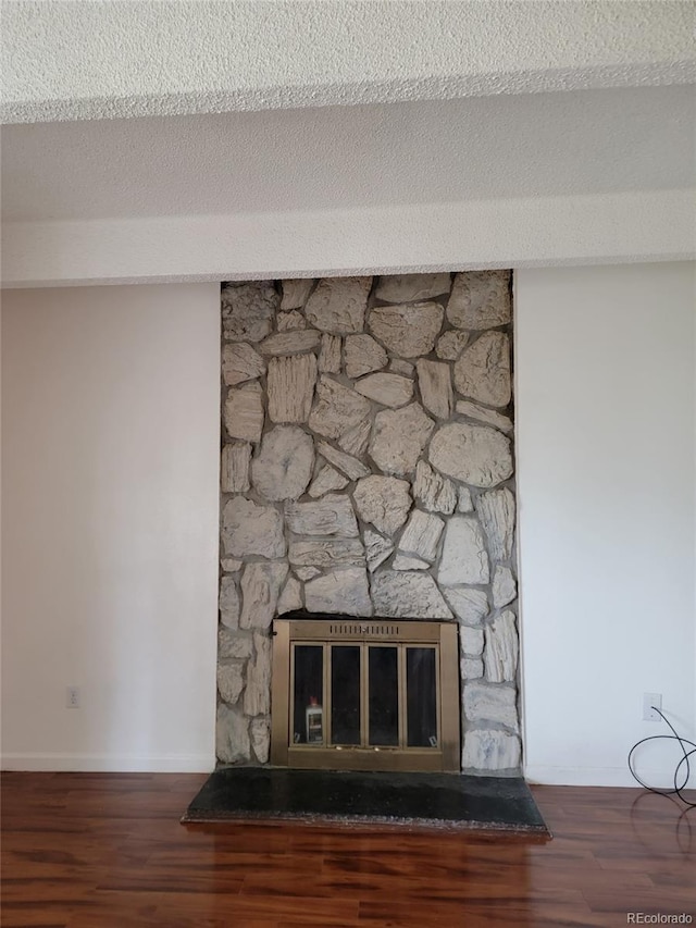 384 S Ironton St Unit 407, Aurora, CO 80012 - detailed view of a stone fireplace, wood finished floors, and baseboards