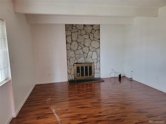 384 S Ironton St Unit 407, Aurora, CO 80012 - unfurnished living room featuring wood finished floors, a fireplace, a textured ceiling, and baseboards