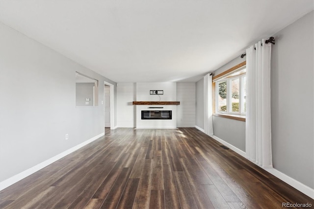 unfurnished living room with dark wood-type flooring