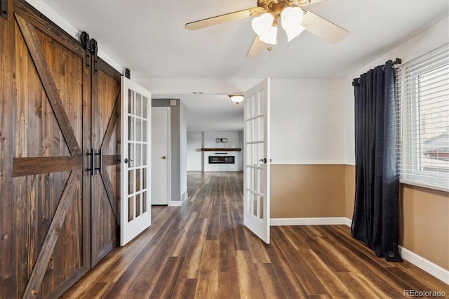 corridor featuring dark hardwood / wood-style flooring, french doors, and a barn door