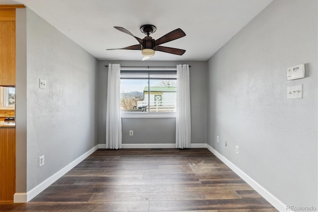 unfurnished room with ceiling fan and dark wood-type flooring