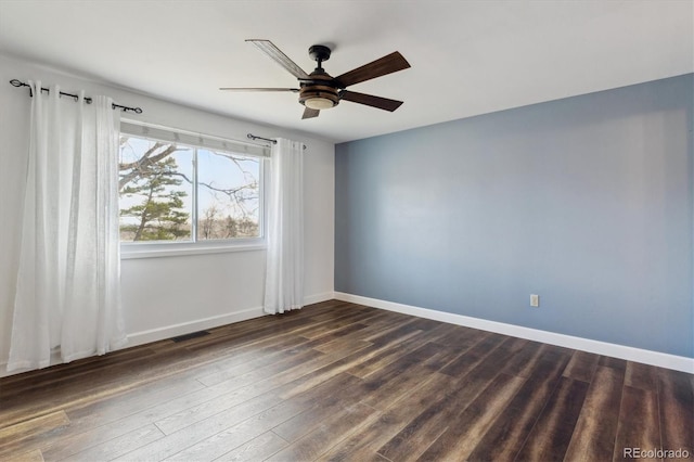 spare room with ceiling fan and dark hardwood / wood-style floors