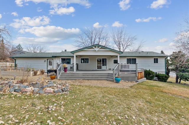 ranch-style home with a deck and a front yard