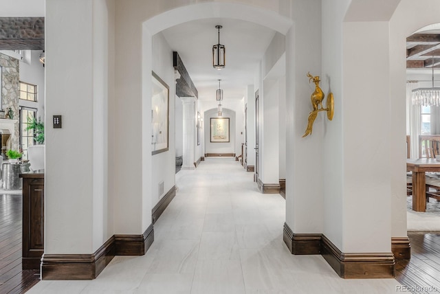 1820 Mallard Dr, Broomfield, CO 80020 - hall featuring arched walkways, baseboards, and a chandelier