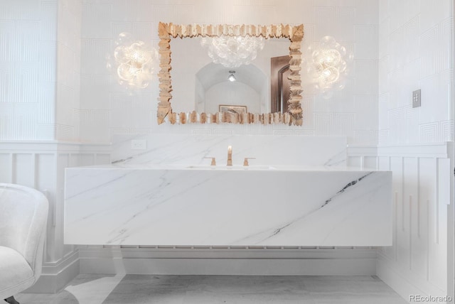 1820 Mallard Dr, Broomfield, CO 80020 - bathroom with a decorative wall, wainscoting, marble finish flooring, a sink, and a chandelier