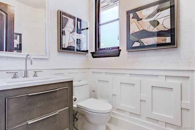 1820 Mallard Dr, Broomfield, CO 80020 - bathroom with vanity, toilet, a wainscoted wall, and a decorative wall