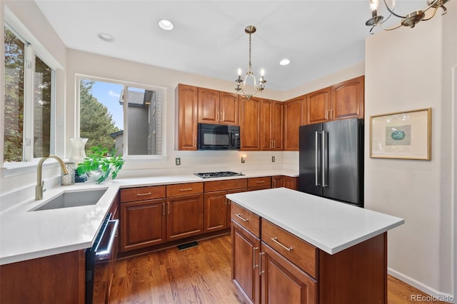 7638 S Hudson Way, Centennial, CO 80122 - kitchen with stainless steel appliances, a chandelier, a sink, wood finished floors, and light countertops