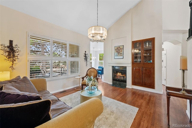 7638 S Hudson Way, Centennial, CO 80122 - living room with arched walkways, a chandelier, high vaulted ceiling, wood finished floors, and a fireplace