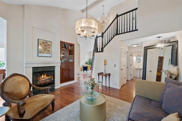 7638 S Hudson Way, Centennial, CO 80122 - living room with wood finished floors, beam ceiling, a chandelier, a tiled fireplace, and baseboards