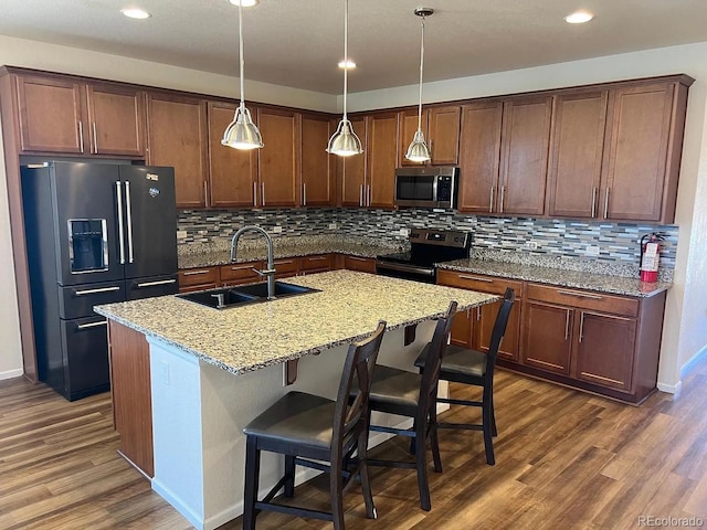 22822 E Union Cir, Aurora, CO 80015 - kitchen with stainless steel appliances, a sink, dark wood finished floors, decorative backsplash, and an island with sink