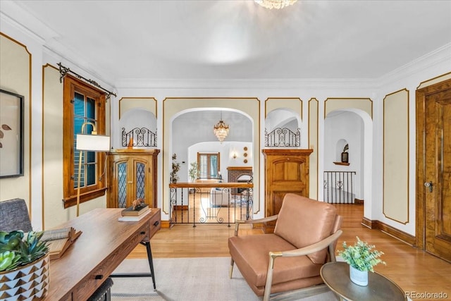 interior space featuring crown molding, arched walkways, wood finished floors, and a notable chandelier