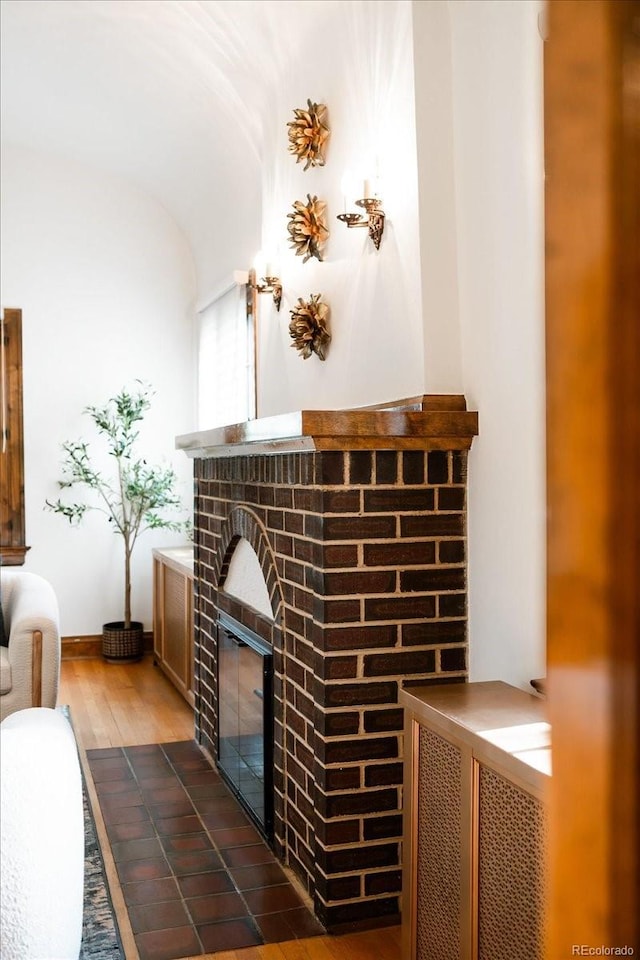 room details featuring a brick fireplace and wood finished floors