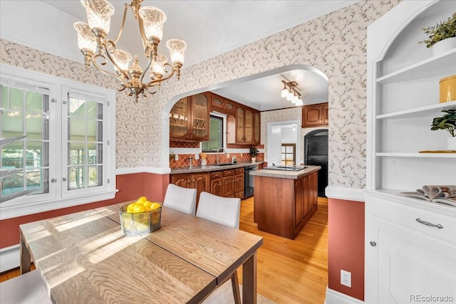 dining area with arched walkways, light wood-type flooring, and wallpapered walls