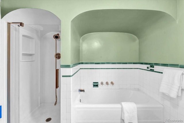 full bath with a shower stall and a garden tub