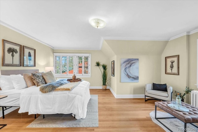 bedroom featuring baseboards, ornamental molding, and light wood-style flooring