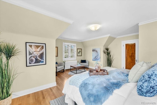 bedroom featuring baseboards, ornamental molding, radiator, and light wood-style floors