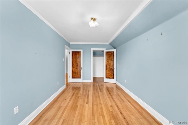 unfurnished bedroom featuring crown molding, baseboards, a closet, and light wood-style flooring