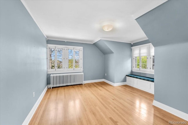 bonus room featuring baseboards, radiator, and wood finished floors