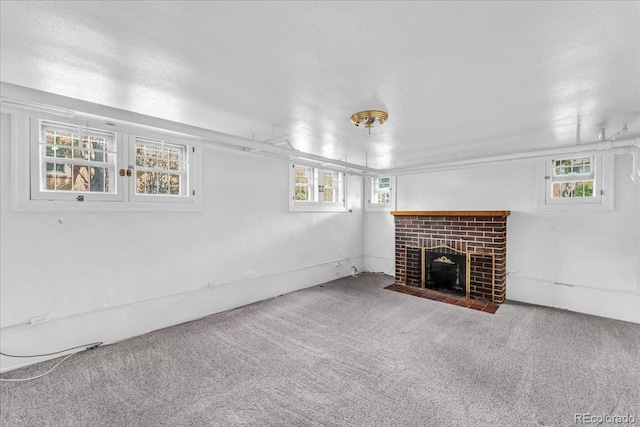 basement featuring carpet, a wealth of natural light, and a fireplace