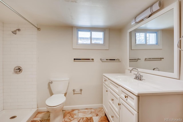 bathroom with vanity, a healthy amount of sunlight, toilet, and tiled shower