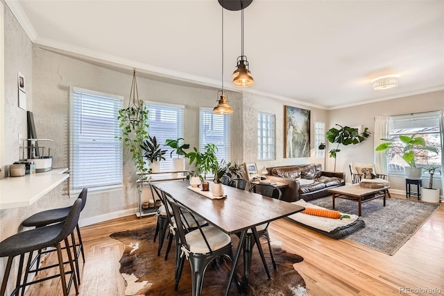 dining area with hardwood / wood-style flooring, plenty of natural light, and ornamental molding