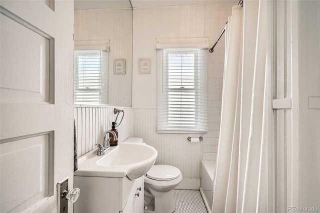 full bathroom with shower / bathtub combination with curtain, a wealth of natural light, vanity, and toilet