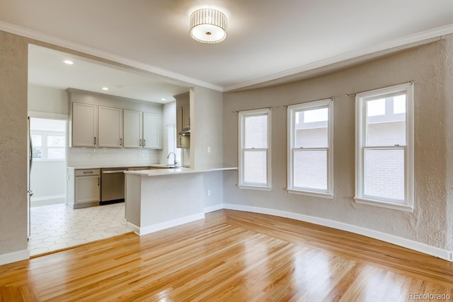 kitchen with dishwasher, backsplash, kitchen peninsula, crown molding, and light wood-type flooring