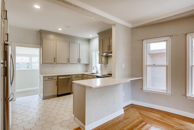 kitchen with kitchen peninsula, appliances with stainless steel finishes, backsplash, crown molding, and sink