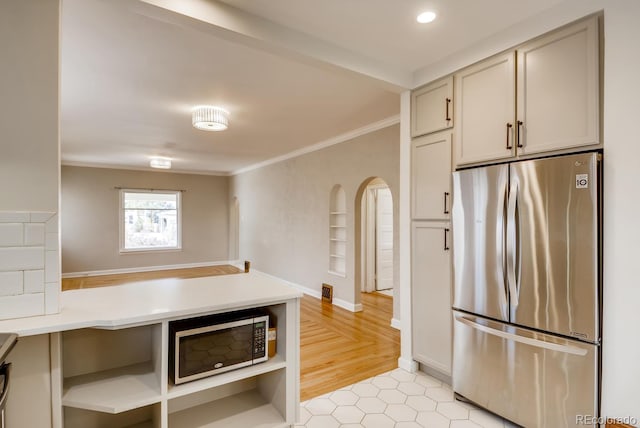 kitchen featuring stainless steel fridge and crown molding