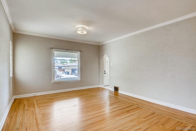 empty room featuring hardwood / wood-style floors and crown molding