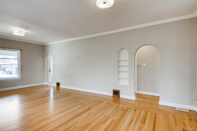 unfurnished room featuring hardwood / wood-style floors, built in features, and ornamental molding