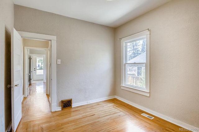 spare room with light hardwood / wood-style floors and a wealth of natural light