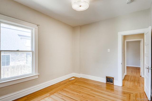 spare room with hardwood / wood-style flooring and a healthy amount of sunlight