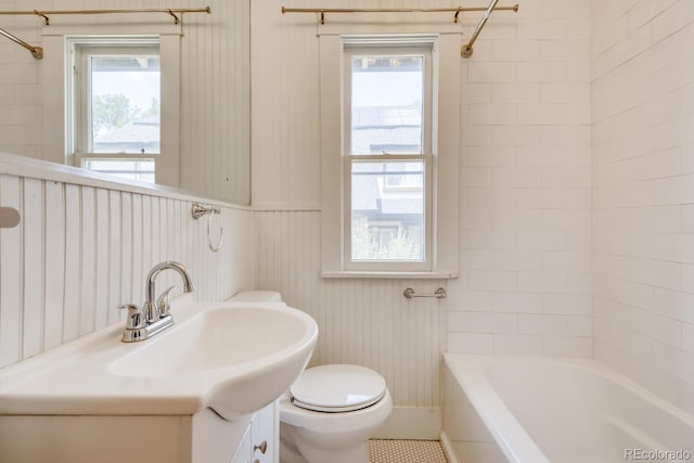 full bathroom featuring vanity, toilet, plenty of natural light, and tiled shower / bath combo