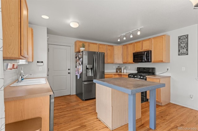 9272 E 108th Ave, Commerce City, CO 80640 - kitchen featuring black appliances, light wood-type flooring, a breakfast bar, a center island, and light brown cabinetry