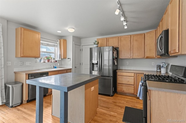 9272 E 108th Ave, Commerce City, CO 80640 - kitchen featuring appliances with stainless steel finishes, light wood-style floors, light brown cabinets, a center island, and rail lighting