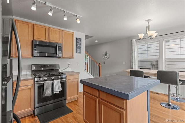 9272 E 108th Ave, Commerce City, CO 80640 - kitchen with stainless steel appliances, light wood-style floors, a chandelier, recessed lighting, and a kitchen island