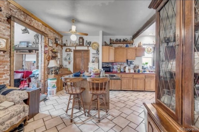 kitchen with ceiling fan and a breakfast bar area