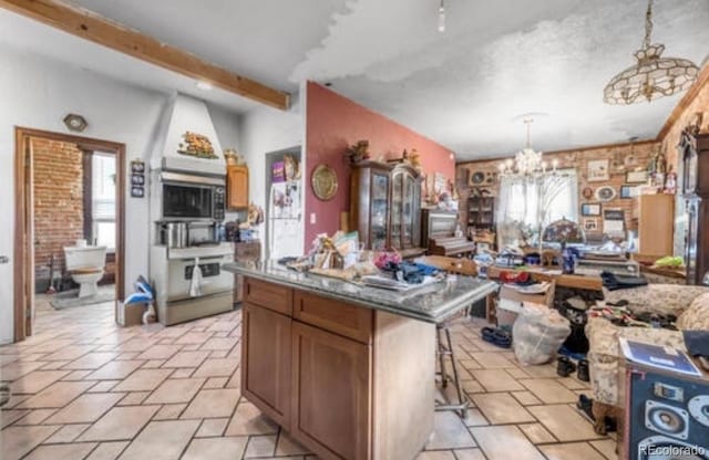 kitchen featuring hanging light fixtures, an inviting chandelier, a breakfast bar area, beamed ceiling, and a center island