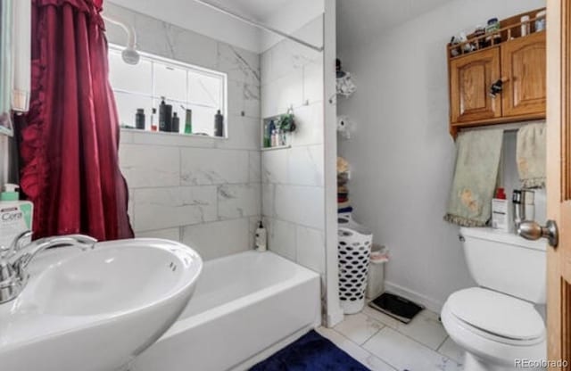 full bathroom with toilet, tiled shower / bath combo, and sink