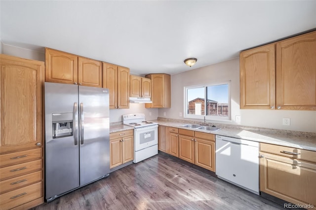 kitchen featuring white appliances, dark wood-style flooring, light countertops, light brown cabinets, and a sink