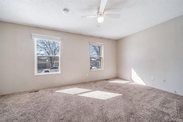 spare room featuring ceiling fan, a textured ceiling, and carpet flooring