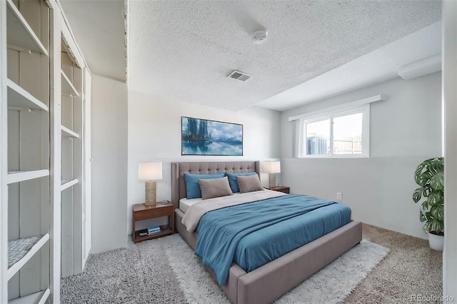 bedroom with visible vents, a textured ceiling, and light colored carpet