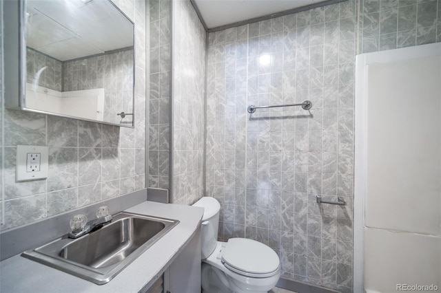 half bathroom featuring toilet, tile walls, and vanity