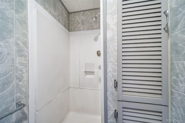 bathroom featuring a tile shower and tile walls