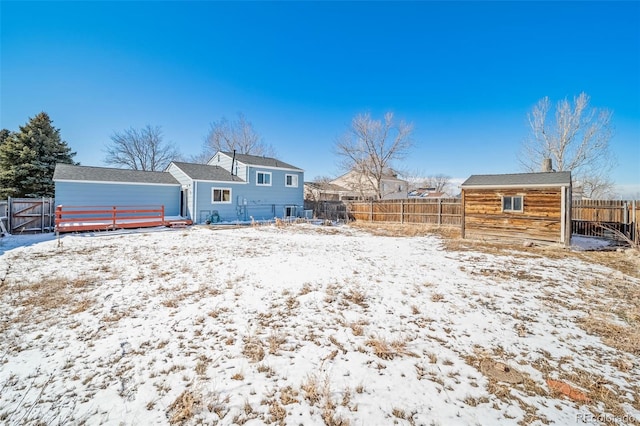 snow covered house with a fenced backyard