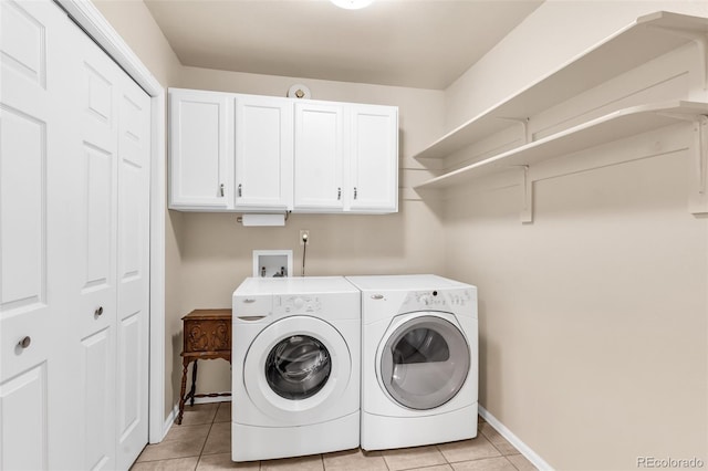 washroom featuring separate washer and dryer, light tile patterned floors, and cabinets